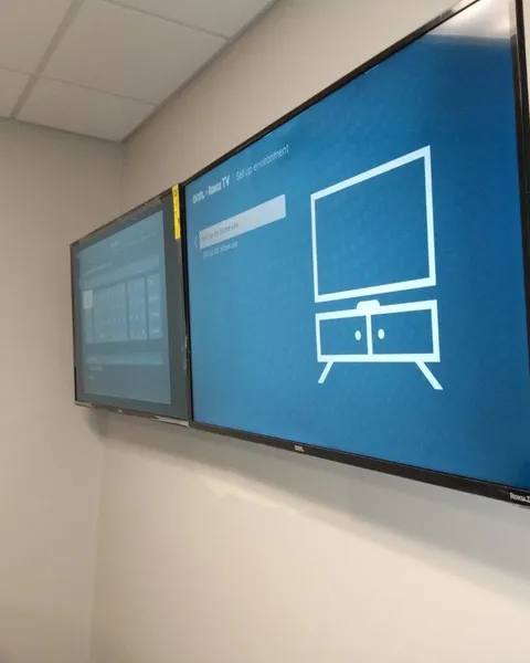 Two TVs mounted side by side in the same room