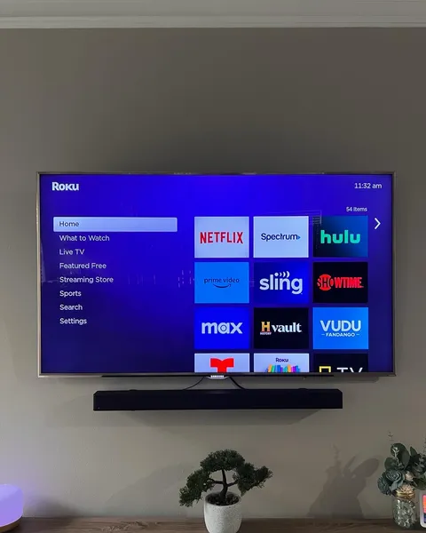 TV installed on a tilt mount with a soundbar and power bridge cable management