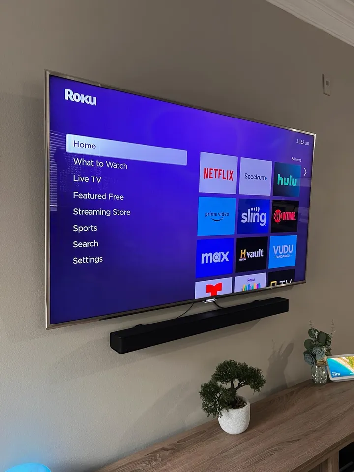 TV installed on a tilt mount with a soundbar and power bridge cable management