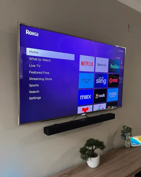 TV installed on a tilt mount with a soundbar and power bridge cable management